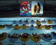 Public en piscine regardant un film