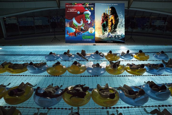Public en piscine regardant un film