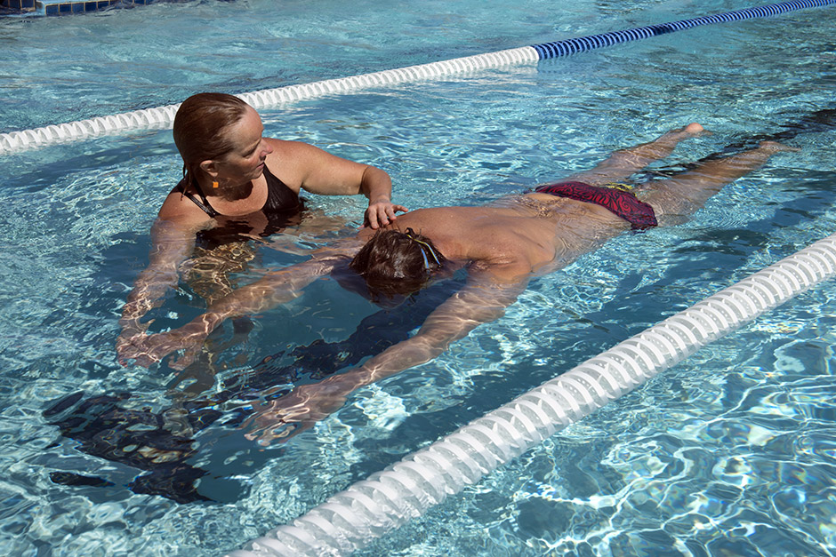 Un adulte apprend à nager dans une piscine